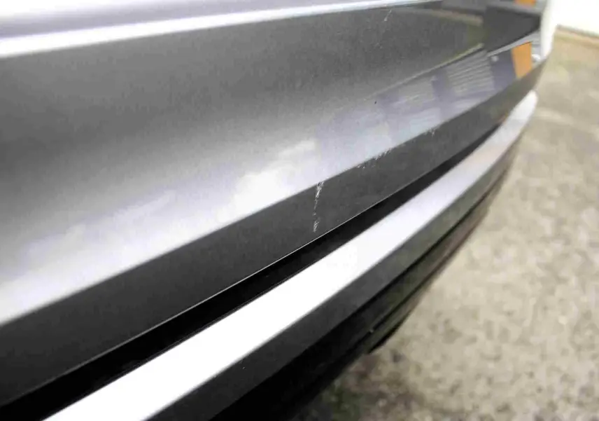 Gros plan sur la console centrale du Range Rover Evoque 2023 gris métal, affichant la climatisation digitale et le levier de vitesse.