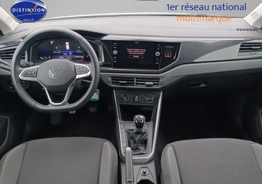 Intérieur avant de la Volkswagen Polo blanche 2025, vue centrée sur le tableau de bord et la boîte manuelle.
