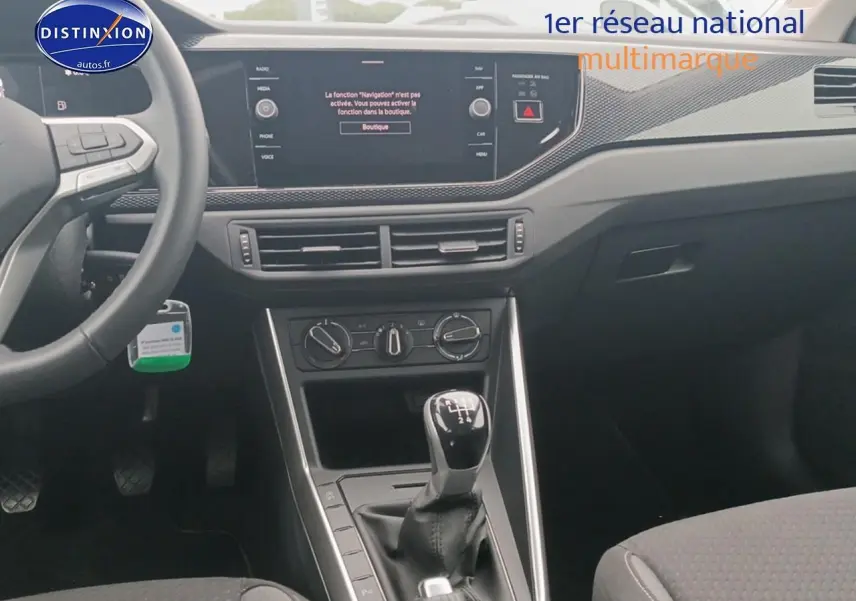 Vue intérieure centrée sur la console centrale et levier de vitesses manuelle d'une Volkswagen Polo blanche 2025.