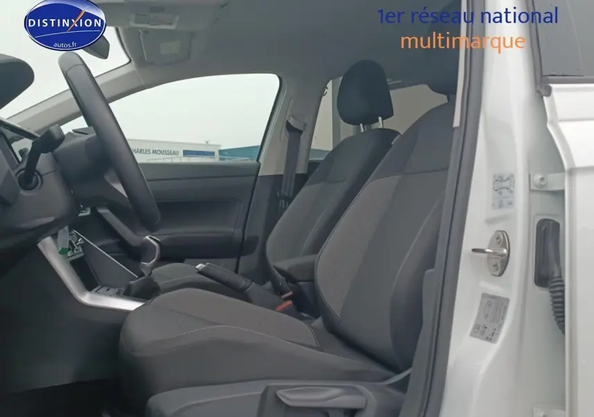 Vue intérieure côté gauche sur les sièges avant noirs et la porte ouverte d'une Volkswagen Polo blanche 2025.