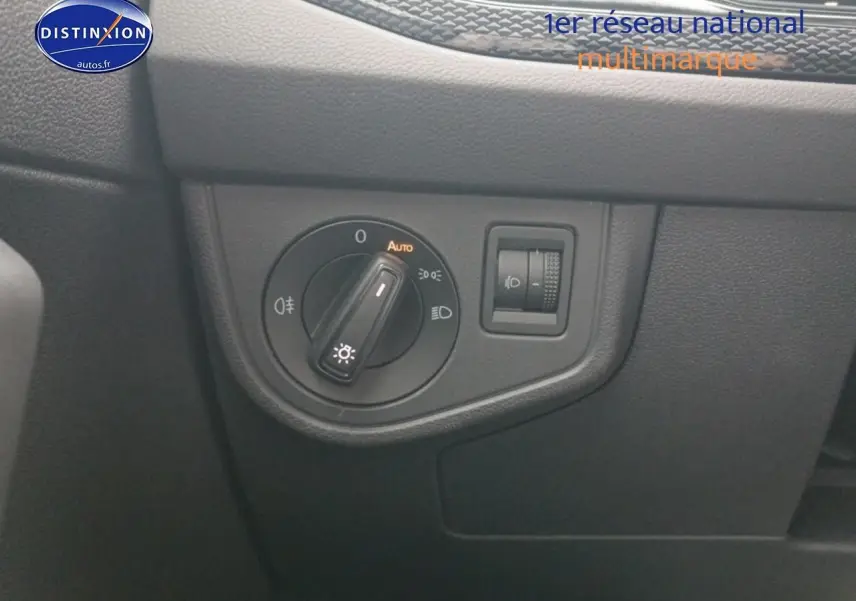 Gros plan sur le bouton de commande des phares du tableau de bord noir de la Volkswagen Polo blanche 2025.