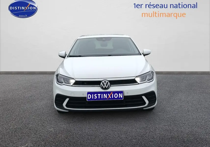 Vue de face d'une Volkswagen Polo blanche pure 2025 avec calandre noire et feux LED allumés.