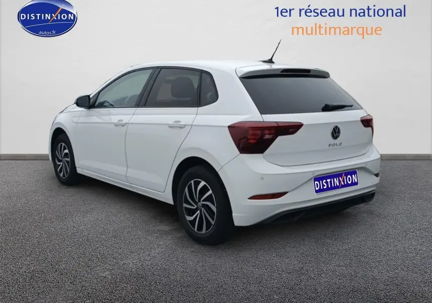 Vue 3/4 arrière droite d'une Volkswagen Polo blanche pure avec vitres arrière surteintées et jantes alliage 15 pouces.