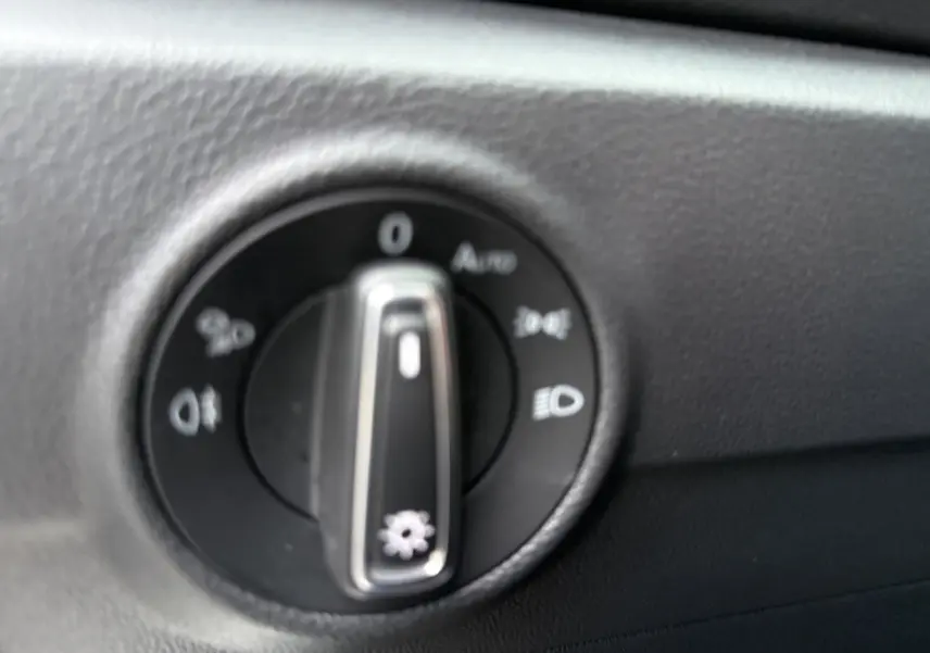 Gros plan sur le sélecteur de commandes d’éclairage intérieur du Volkswagen T-Roc 2025, tableau de bord noir.