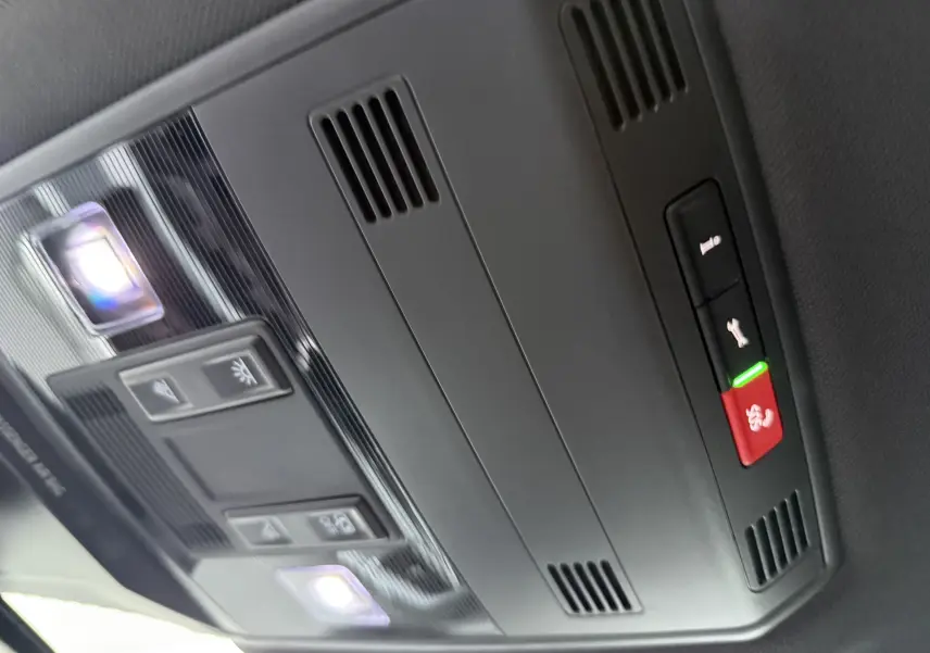 Plafonnier intérieur noir du Volkswagen T-Roc 2025 avec éclairages LED et boutons de commande, vue en léger contre-plongée.