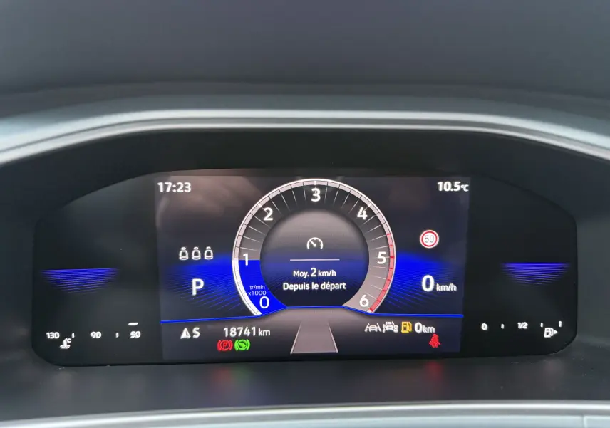 Tableau de bord numérique du Volkswagen T-Roc 2025 affichant la vitesse, le régime moteur et les alertes, avec fond noir et détails bleus.