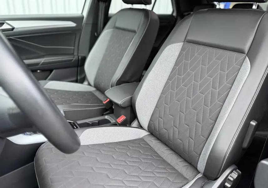 Gros plan sur les sièges avant gris et noirs du Volkswagen T-Roc 2.0 TDI 150ch Life Plus, intérieur moderne et soigné.