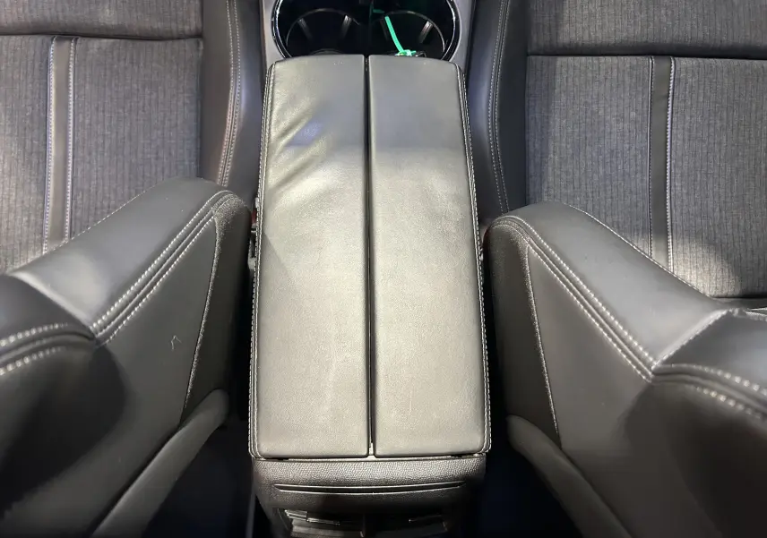 Vue plongeante sur l'accoudoir central en cuir noir et les sièges avant en tissu gris du Peugeot 508 SW 2019.
