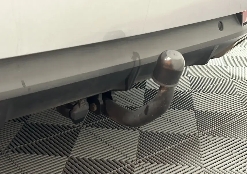 Gros plan sur l'attelage arrière d'une Peugeot 508 SW gris Platinium, avec protection en caoutchouc sur la boule.