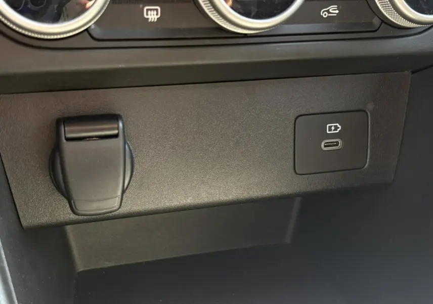 Gros plan sur la console centrale noire du Dacia Sandero Stepway 2025, montrant prise USB-C et prise 12V.