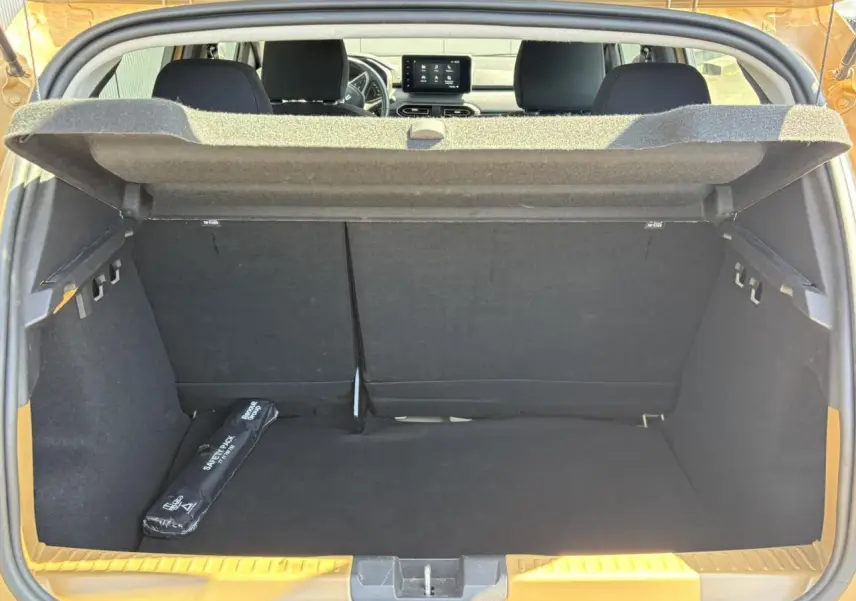 Coffre ouvert d’une Dacia Sandero Stepway Beige Safari, vue arrière montrant l’espace de chargement et l’écran tactile du tableau de bord.