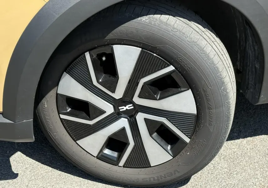 Gros plan sur la roue avant gauche du Dacia Sandero Stepway beige Safari avec jante au design noir et gris.