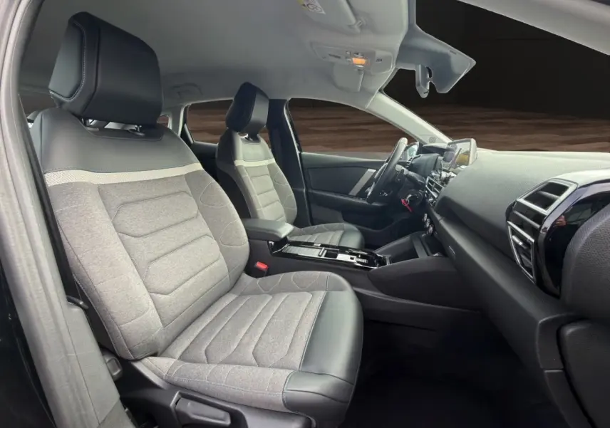 Intérieur de la Citroën C4 2023 noir, vue côté gauche avant, sièges tissu gris avec appuis-tête cuir noir.