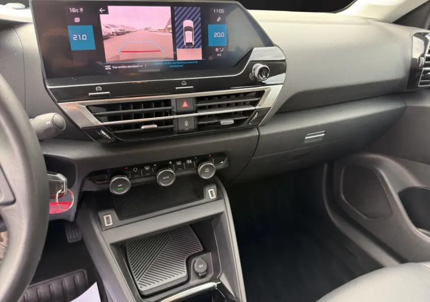 Vue intérieure de la planche de bord et console centrale du Citroën C4 2023 avec écran tactile et commandes climatisation.