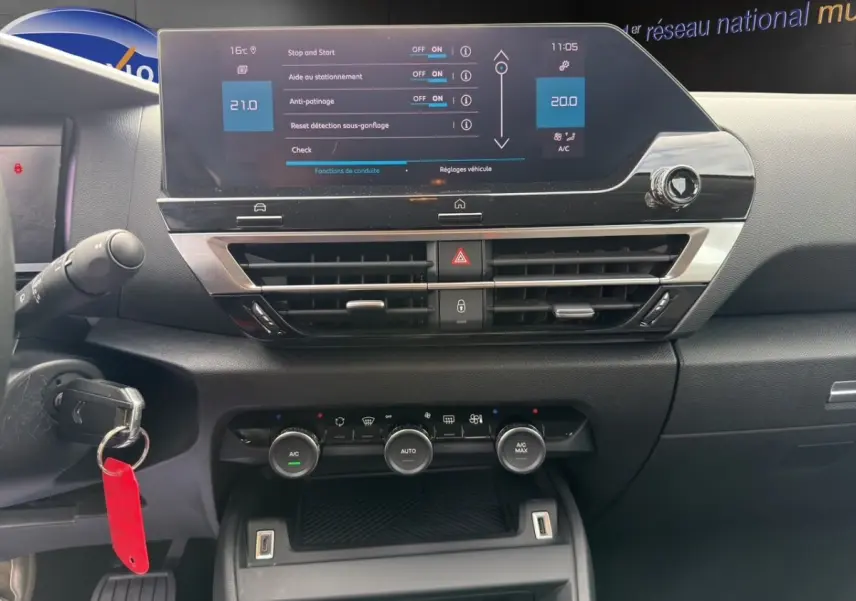 Vue rapprochée du tableau de bord central tactile noir de la Citroën C4 2023 avec commandes climatisation et affichage digital.