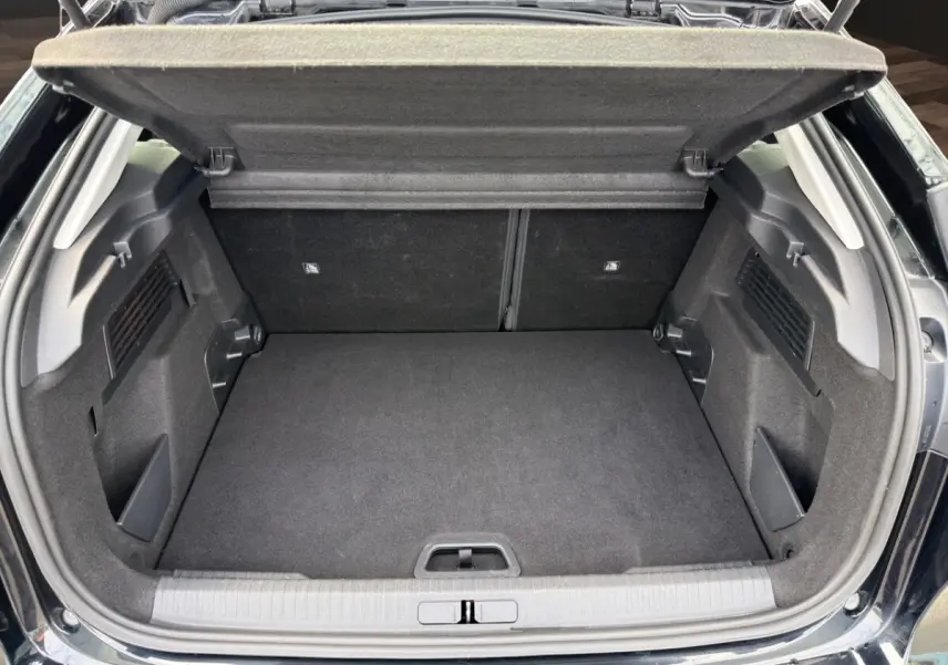 Coffre ouvert de la Citroën C4 noir 2023, vue arrière montrant l'espace de chargement vide et la tablette de coffre relevée.