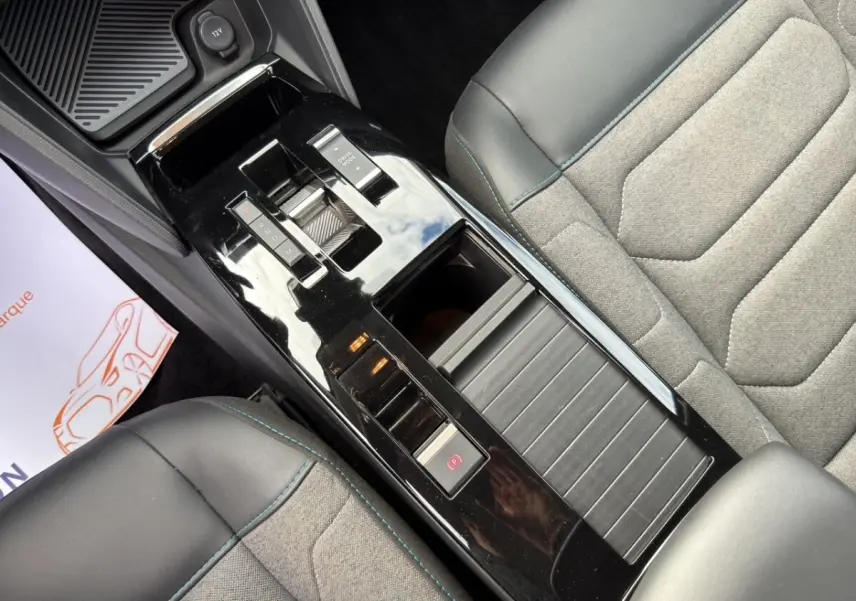 Vue plongeante sur la console centrale noire brillante et les sièges gris avec surpiqûres bleues de la Citroën C4 2023.