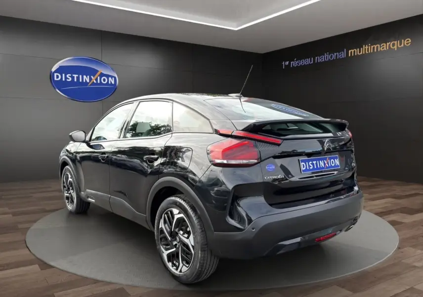 Vue 3/4 arrière droite d'une Citroën C4 noire 2023 avec jantes stylisées et feux arrière LED distinctifs.