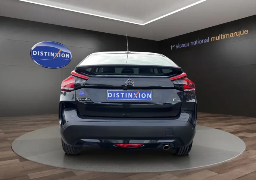 Vue arrière d'une Citroën C4 noire 2023 avec feux LED et sortie d'échappement visible en showroom.
