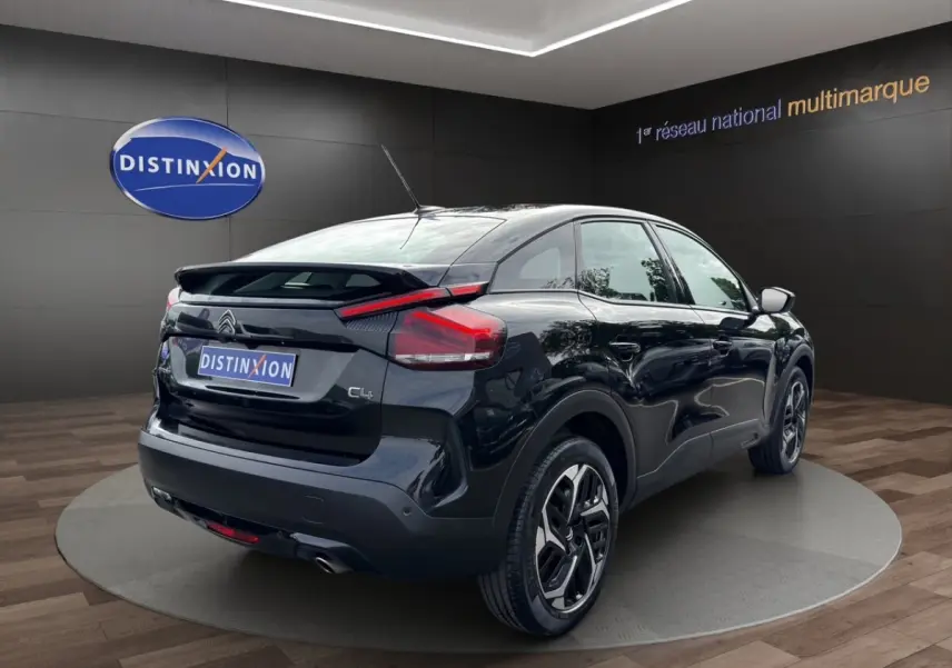 Vue 3/4 arrière droite d'une Citroën C4 noire 2023 avec toit incliné et feux arrière LED distinctifs.