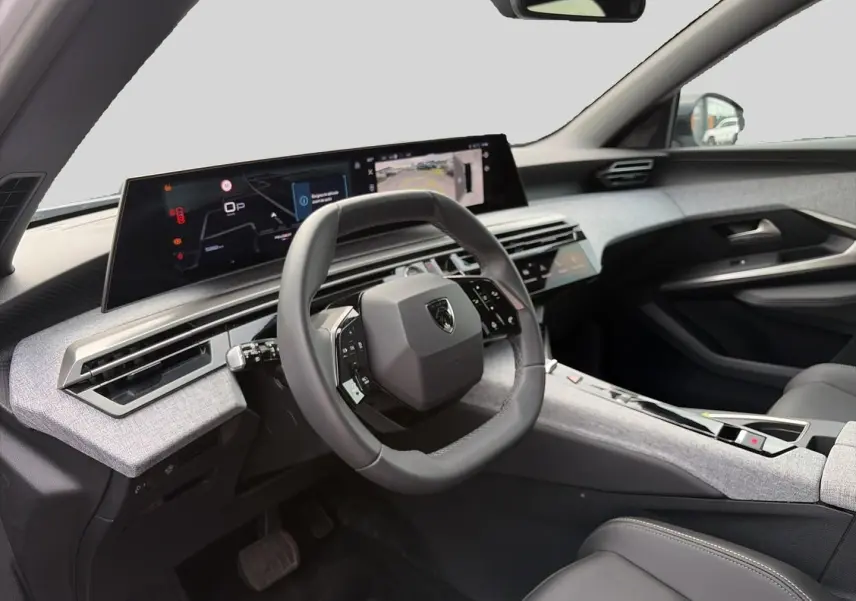 Vue intérieure côté conducteur du Peugeot 5008 Hybrid 145 allure e-dcs6 2025, volant cuir et tableau de bord numérique.