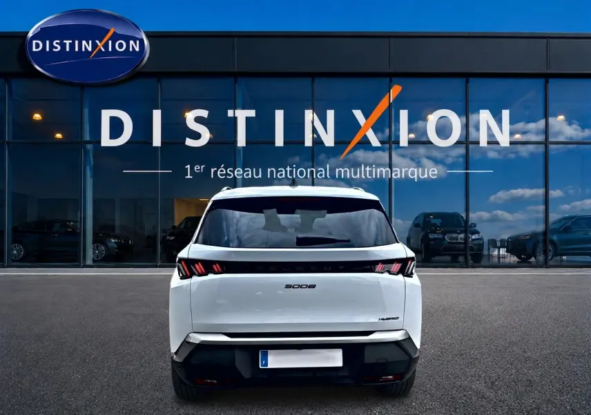 Vue arrière d'un Peugeot 5008 blanc Hybrid 145 allure e-dcs6 2025, avec feux arrière LED et lunette arrière surteintée.