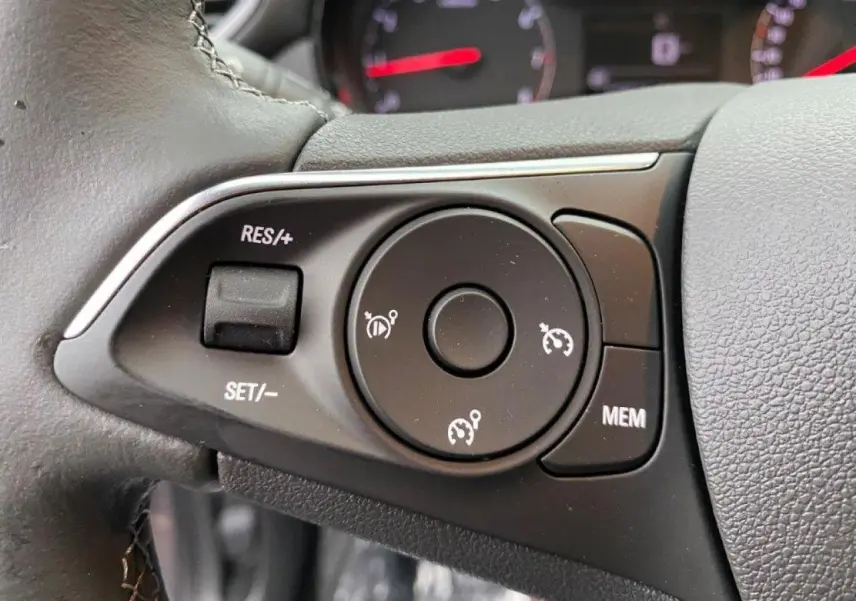 Gros plan sur les commandes de régulateur de vitesse au volant cuir de l'Opel Crossland gris métallisé 2022.