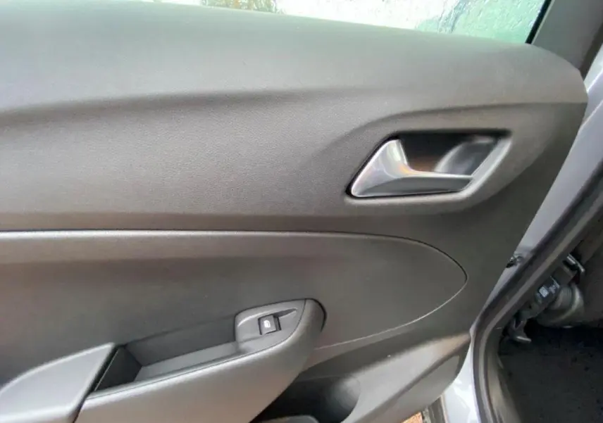 Gros plan sur la porte intérieure côté conducteur de l'Opel Crossland gris métallisé, avec poignée et bouton de verrouillage.