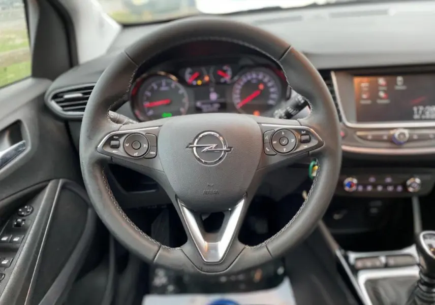 Volant en cuir multifonction de l'Opel Crossland 2022, vue centrée sur le tableau de bord et commandes au volant.