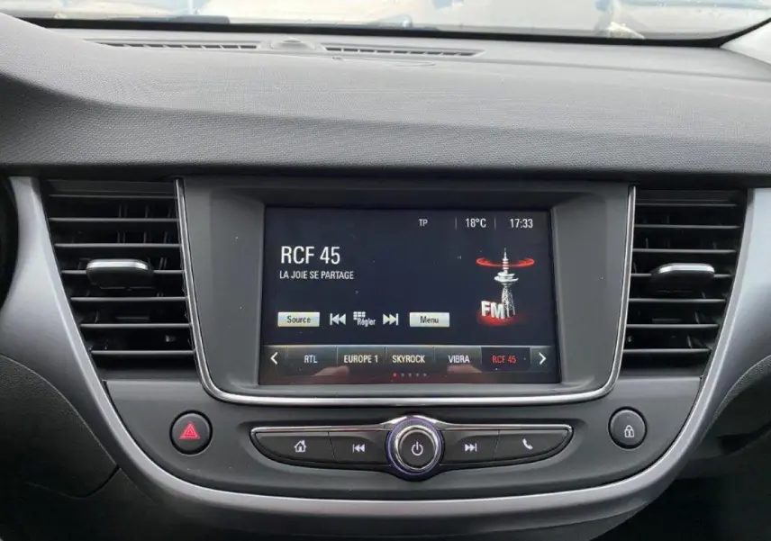 Vue rapprochée de l'écran tactile multimédia central de l'Opel Crossland gris métallisé, affichant une radio FM.