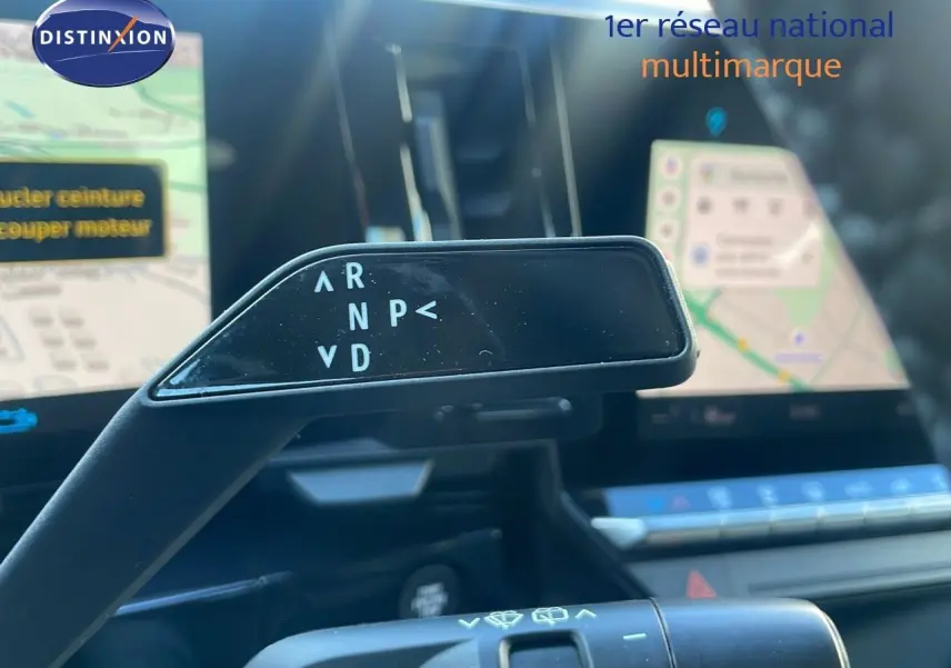 Le levier de vitesses automatique noir dans l'habitacle du Renault Austral blanc glacier, avec écran tactile en arrière-plan.