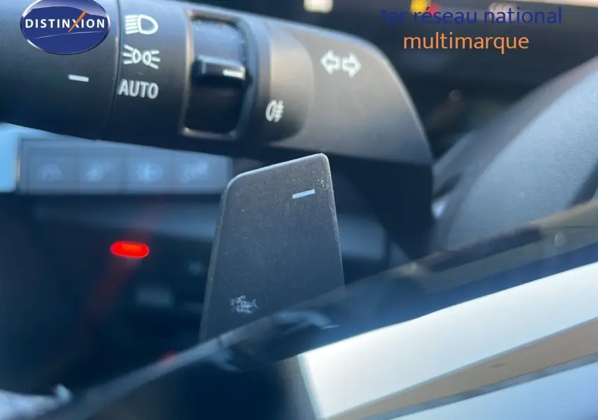 Gros plan sur la palette de changement de vitesses et la commande des phares dans l'habitacle du Renault Austral blanc glacier 2023.