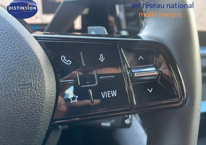 Gros plan sur les commandes du volant du Renault Austral blanc glacier, mettant en valeur les boutons multifonctions et le design moderne.