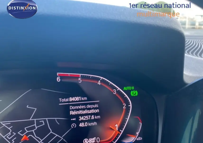 Tableau de bord numérique d'une BMW Série 3 G20 noire, affichant le compteur et la navigation.