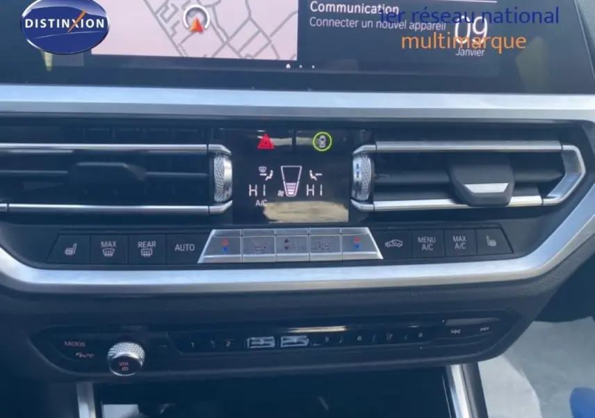 Vue rapprochée du tableau de bord de la BMW Série 3 G20 noire, mettant en valeur les commandes de climatisation et l'écran central.