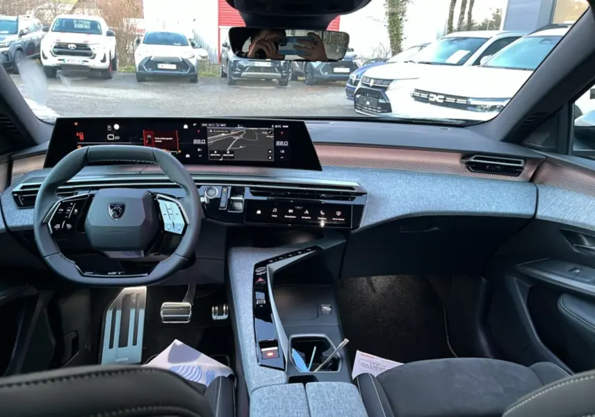 Vue intérieure du tableau de bord et volant cuir multifonctions du Peugeot 5008 Hybrid 145 GT Alcantara 2025.