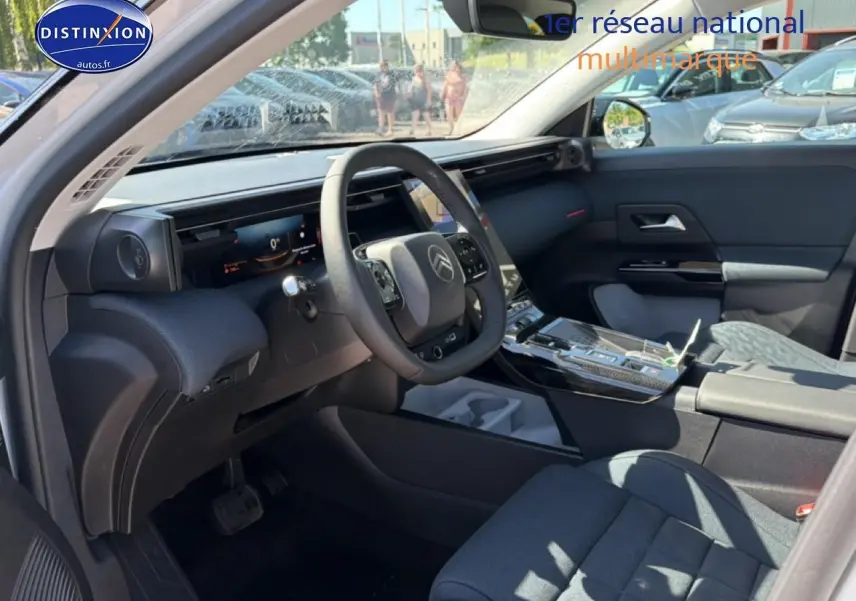 Vue intérieure côté conducteur du Citroën C5 Aircross blanc/noir 2026, tableau de bord numérique et console centrale moderne.