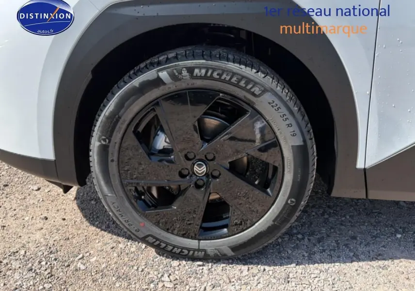 Gros plan sur la roue avant droite noire et jante alliage 19 pouces du Citroën C5 Aircross blanc et noir.