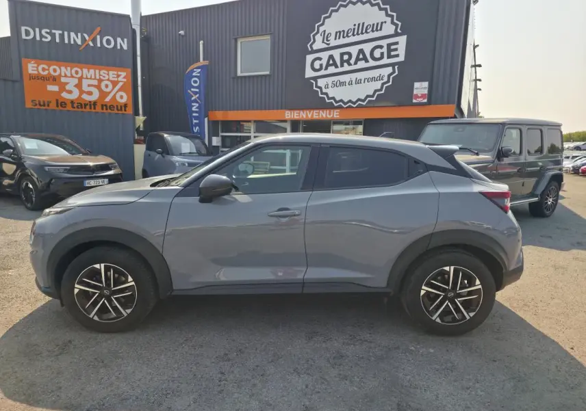 Nissan Juke gris métallisé vue de profil côté gauche, avec jantes alliage 17 pouces et vitres teintées.
