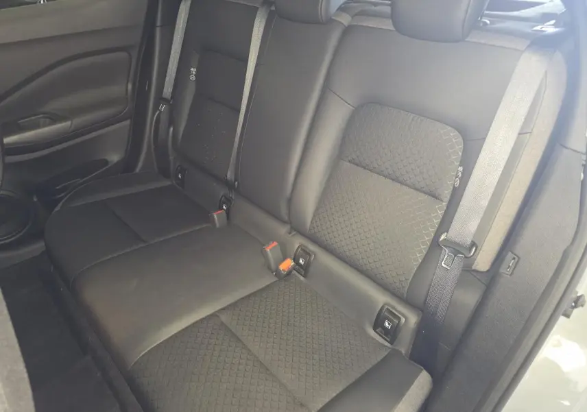 Vue intérieure sur la banquette arrière noire mixte TEP/tissu du Nissan Juke 2025 avec ceintures et appuis-tête réglables.