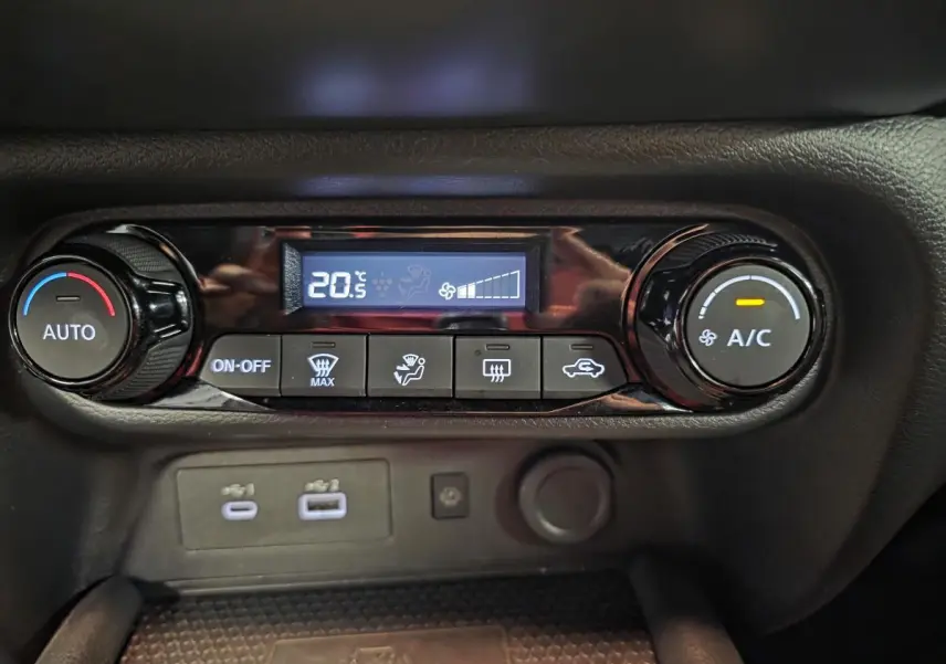 Panneau de commande de climatisation automatique du Nissan Juke 2025, avec affichage digital et boutons noirs.