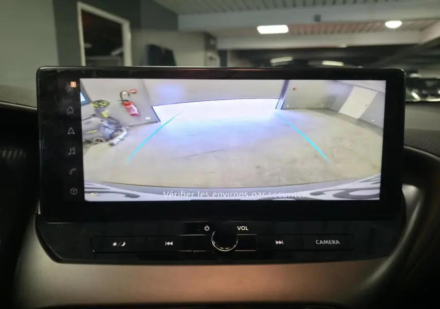 Écran tactile intérieur du Nissan Juke 2025 affichant la caméra de recul avec lignes d’aide au stationnement.