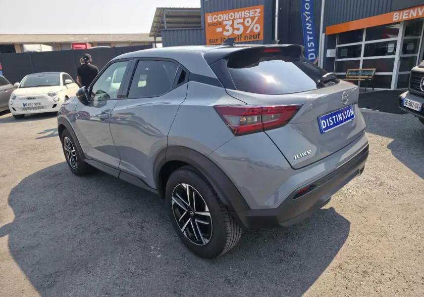 Nissan Juke gris métallisé vue 3/4 arrière droit, jantes alliage 17'', toit noir et feux arrière LED.