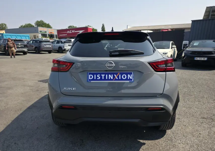 Vue arrière d'un Nissan Juke gris métallisé 2025 avec feux LED et antenne aileron de requin noire.