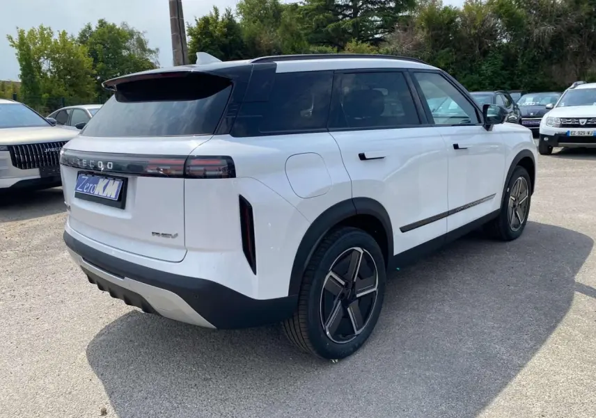 SUV JAECOO J7 blanc khaki vu en 3/4 arrière droit, avec toit noir et feux arrière horizontaux fins.