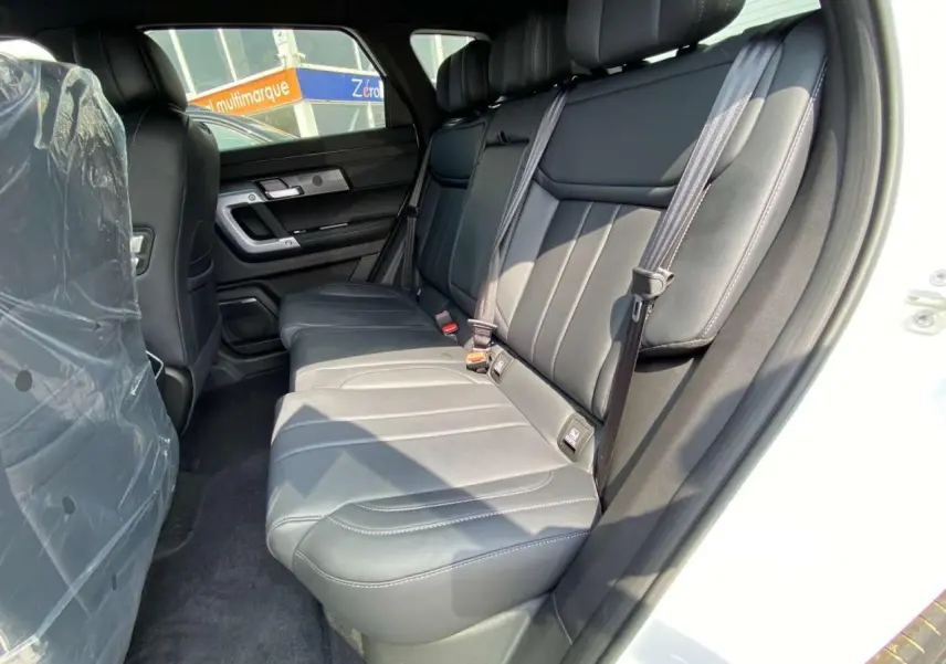Vue intérieure côté droit des sièges arrière en cuir noir du SUV JAECOO J7 blanc khaki, version hybride 2026.