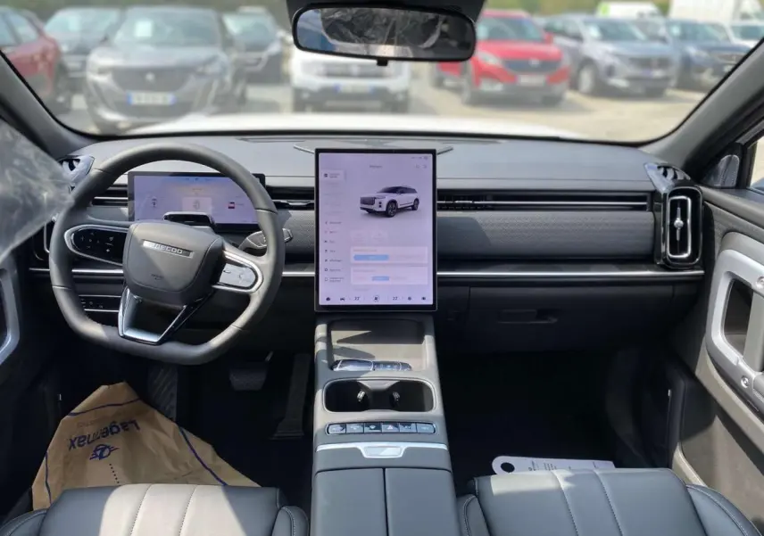 Vue intérieure avant du SUV JAECOO J7 2026, avec tableau de bord moderne, écran tactile vertical et volant multifonction.