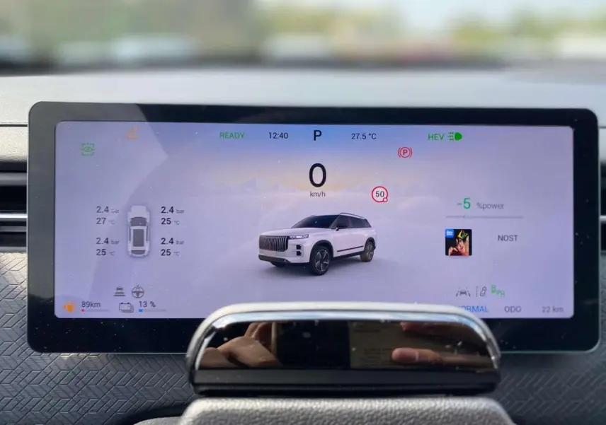 Écran numérique intérieur du JAECOO J7 2026 affichant un SUV blanc khaki en vue de face avec données de conduite.