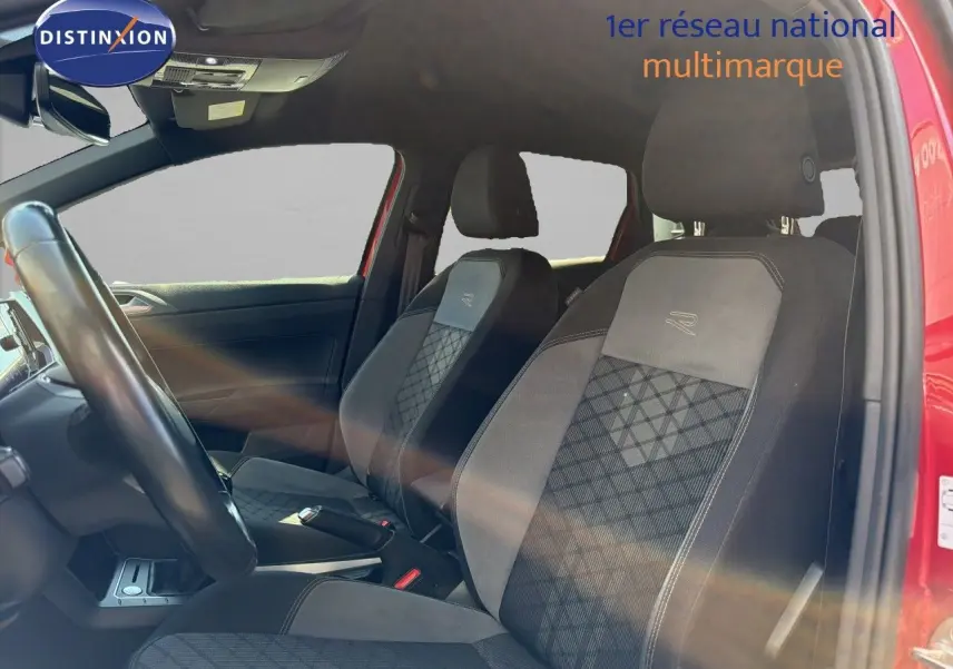 Vue intérieure côté conducteur de la Volkswagen Polo rouge Roi 2023, sièges R-Line avec surpiqûres et volant visible.