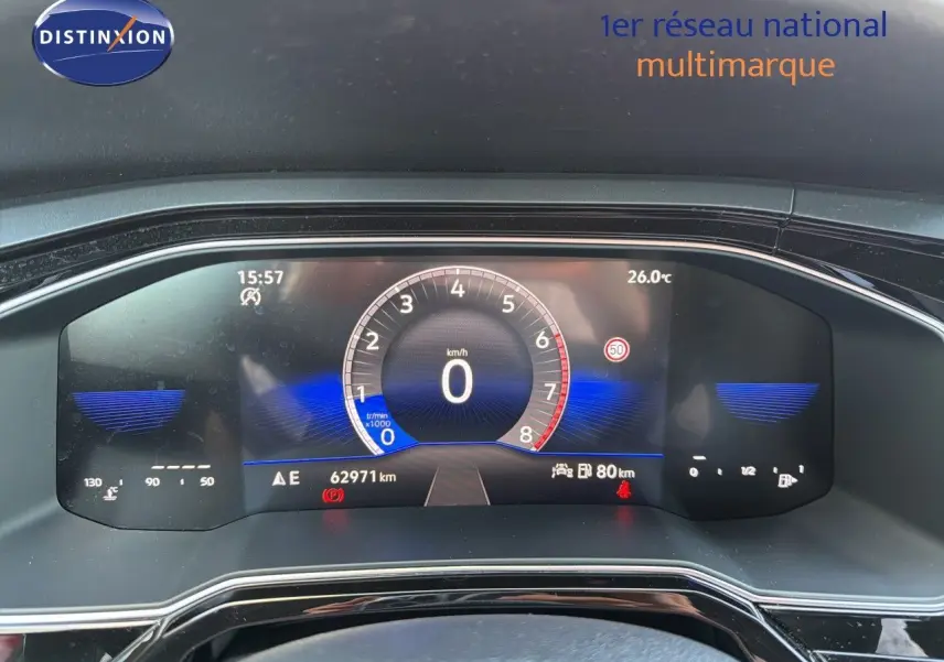 Vue rapprochée du tableau de bord numérique de la Volkswagen Polo rouge, affichant la vitesse à 0 km/h et 62 971 km au compteur.